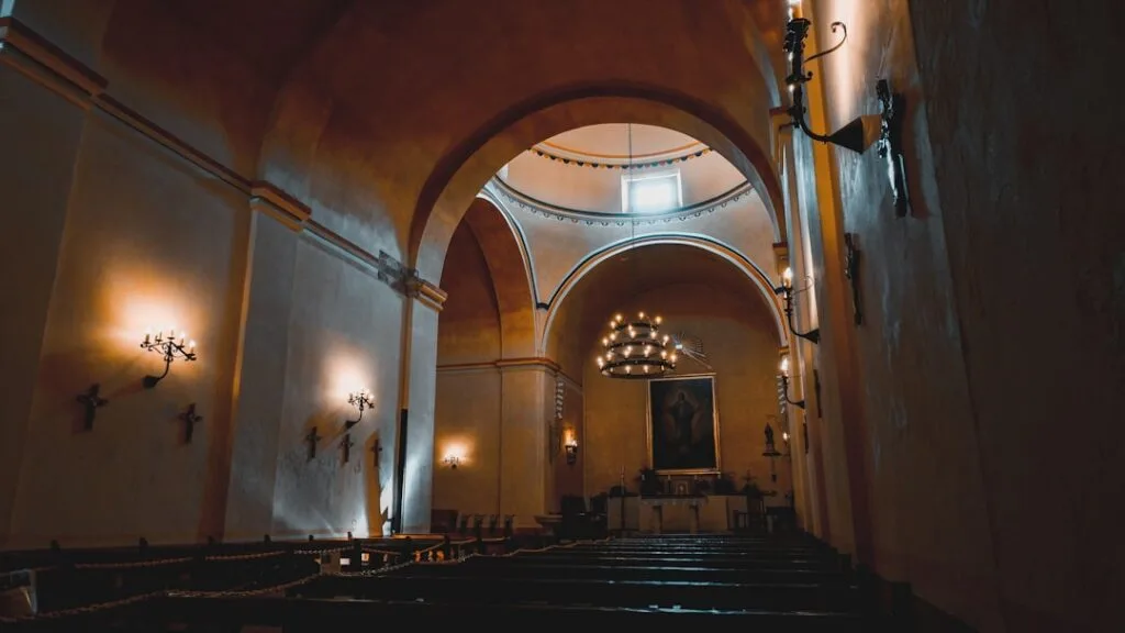 Nef paisible d'une église florentine, bancs en bois et chandeliers allumés