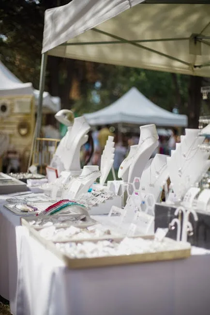 Freiluftstand mit Schmuck auf weißen Präsentationsbüsten unter Marktzelten