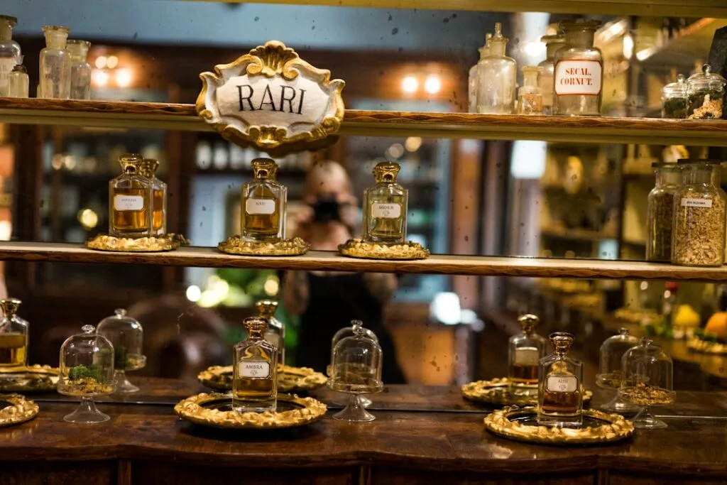 Étagère d'apothicaire présentant flacons de parfum RARI sous cloches