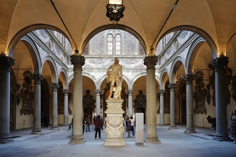 Arkadeninnenhof mit zentraler Marmorskulptur und Besuchern in Florenz