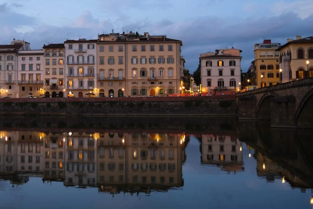 Abendliche Häuserfront an der Arno mit Spiegelung in Florenz