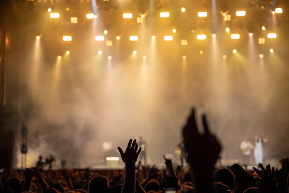 Public levant les mains devant une scène éclairée lors d'un concert à Florence