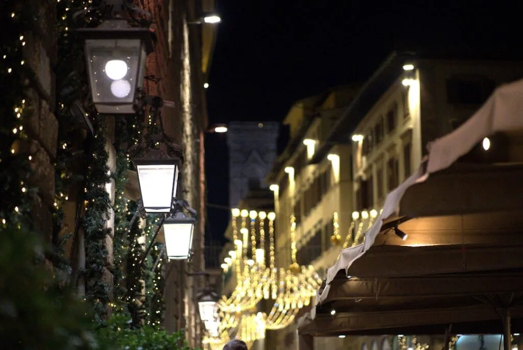 Beleuchtete Gasse in Florenz mit Laternen und festlichen Lichterketten