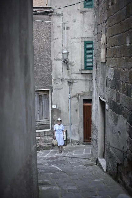 Ruelle pavée de Florence avec femme vêtue de blanc portant sac