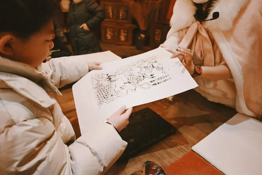 Kind zeigt gezeichnetes Blatt, Betreuerin erklärt im Familienworkshop in Florenz