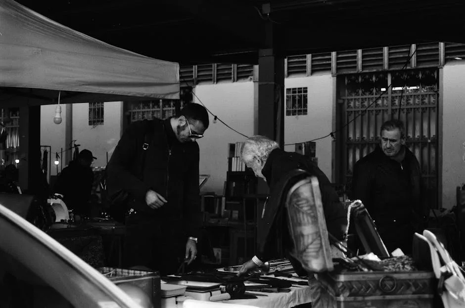 Drei Männer betrachten Flohmarktware an einem überdachten Stand in Florenz