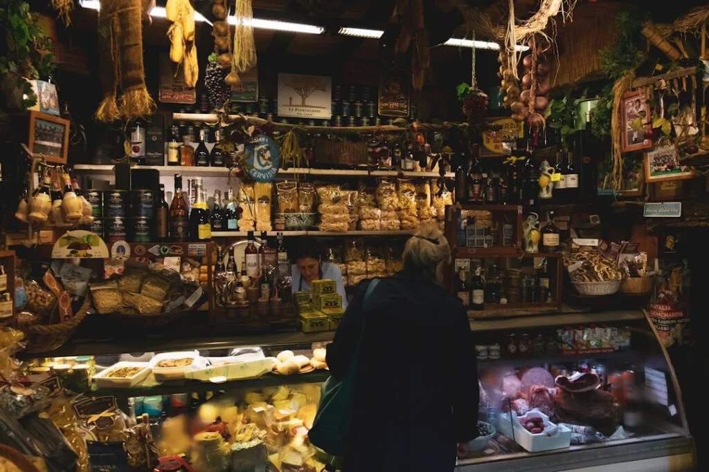 Eine Person steht am Käsetresen eines Delikatessengeschäfts in Florenz