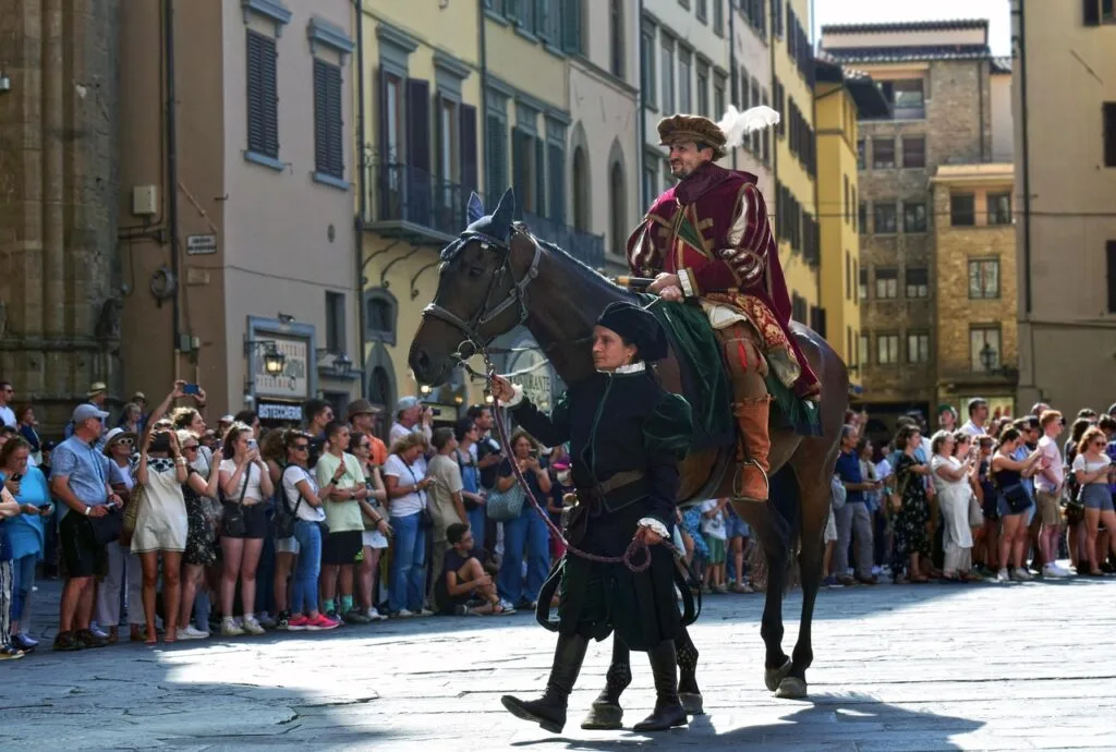 Reiter in historischem Gewand geführt durch Florenz bei Piazza Santa Croce, Zuschauer