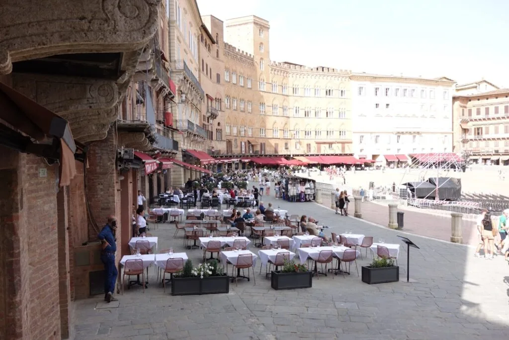 Tische mit weißen Tischdecken auf der Piazza del Campo in Siena