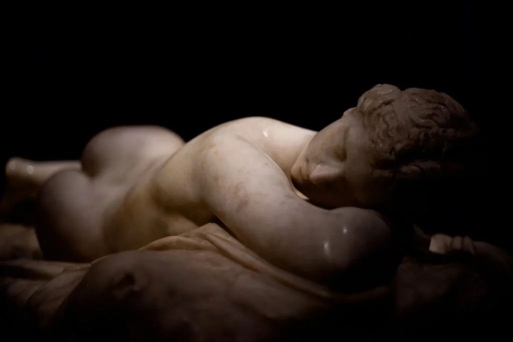 Sculpture en marbre d'un enfant endormi à l'Accademia, éclairée