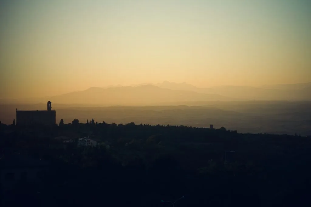 Silhouette einer toskanischen Stadt bei Sonnenuntergang, Volterra im Dunst