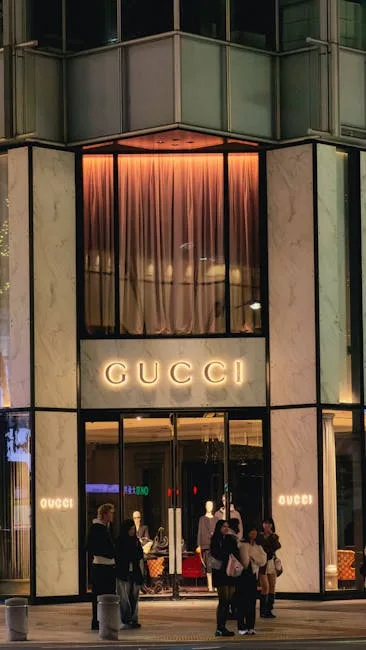 Beleuchtete Gucci-Fassade mit Schaufenster und Passanten abends in Florenz
