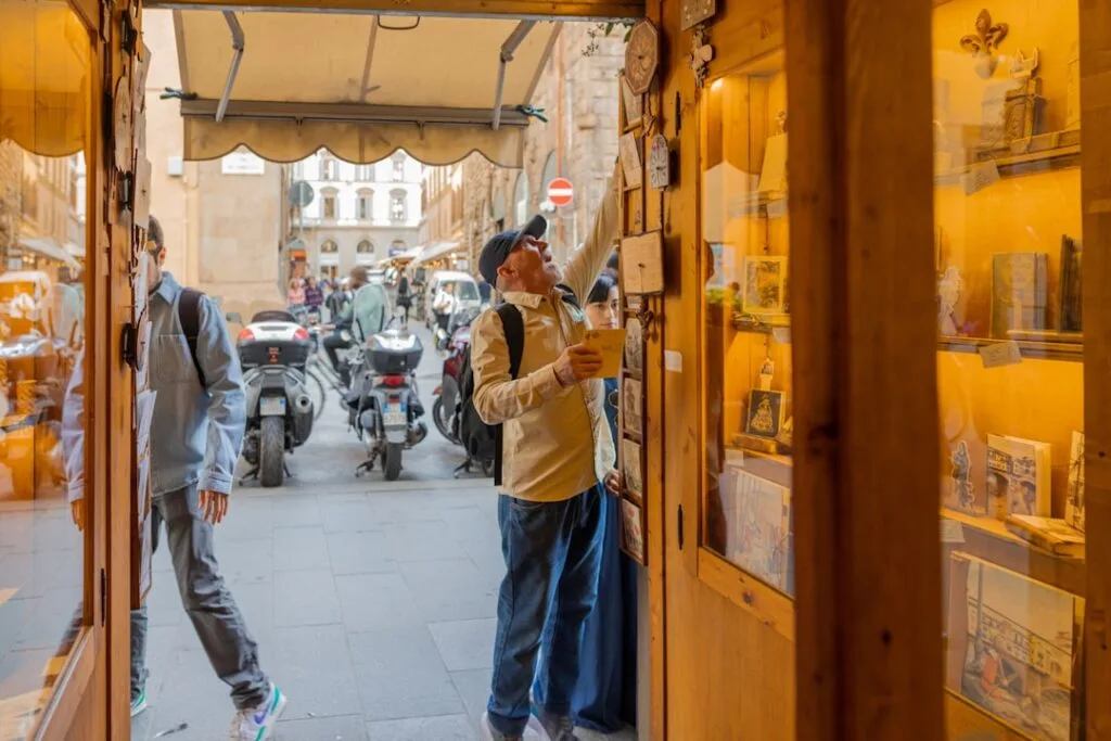 Touristen betrachten Souvenirs im offenen Laden an einer Straße in Florenz