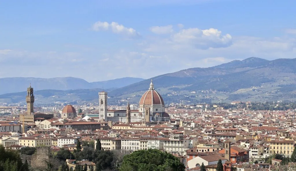 Weite Tagesaufnahme von Florenz mit Domkuppel und umliegenden Hügeln.