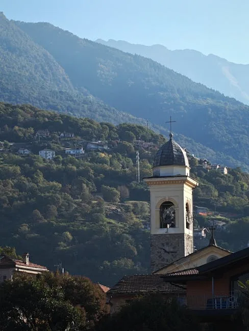 Clocher d'une église rurale au premier plan, montagnes en arrière-plan