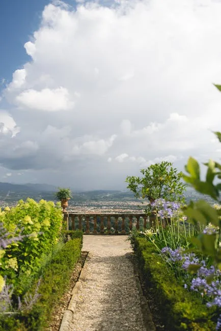 Allée de gravier, massifs fleuris et balustrade offrant vue sur Florence
