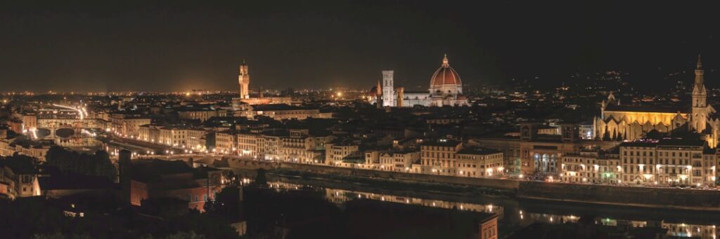 Night panorama of Florence skyline with Duomo and illuminated Arno riverbanks.